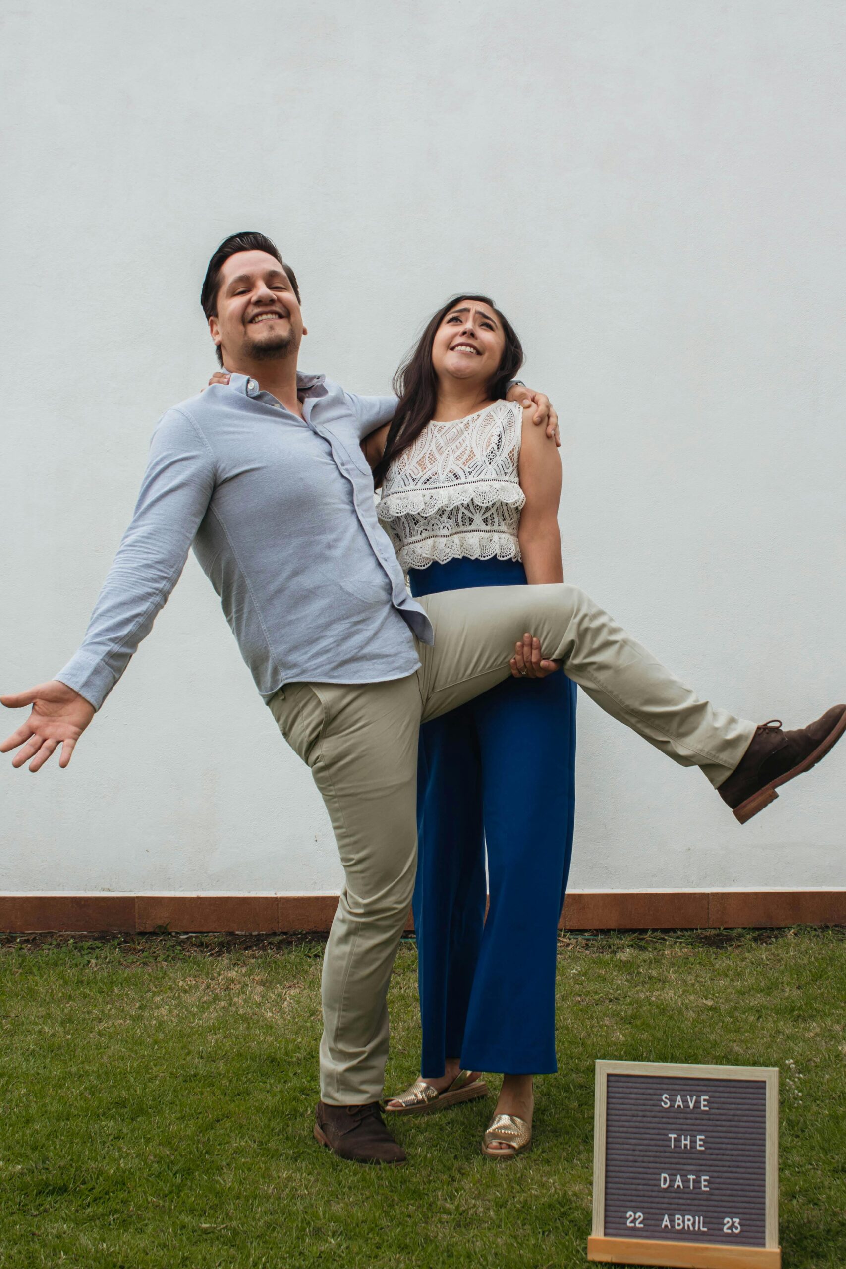 Happy couple sharing a fun moment while posing for their wedding invitation photo.