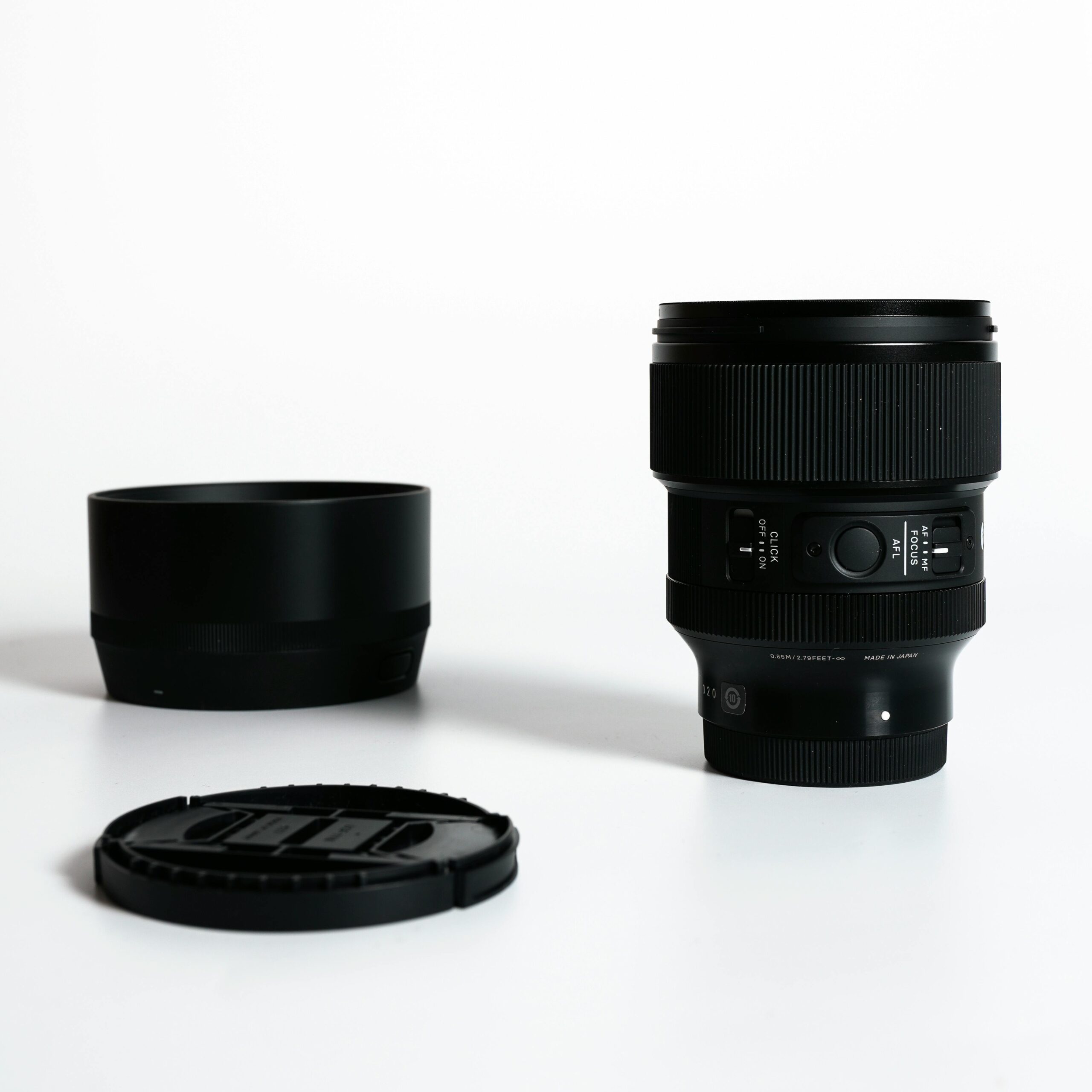 A sleek camera lens with cap and hood, perfect for photography enthusiasts.